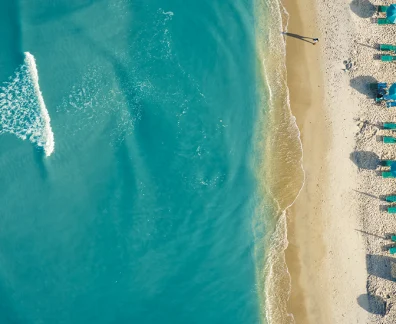 Aerial View of Beach with Turquoise Water and Sun Loungers